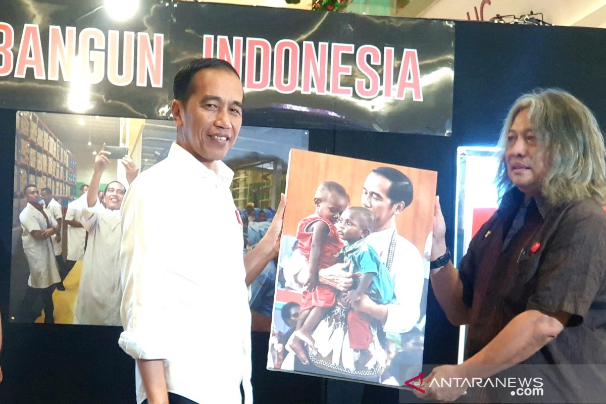 Jokowi enchanted by his photo holding two native Papuan kids