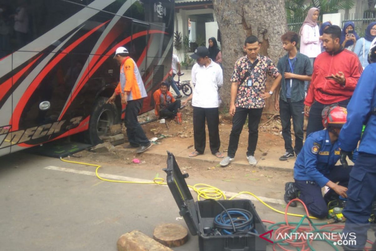 Bus pariwisata terperosok di saluran air Jalan Matraman