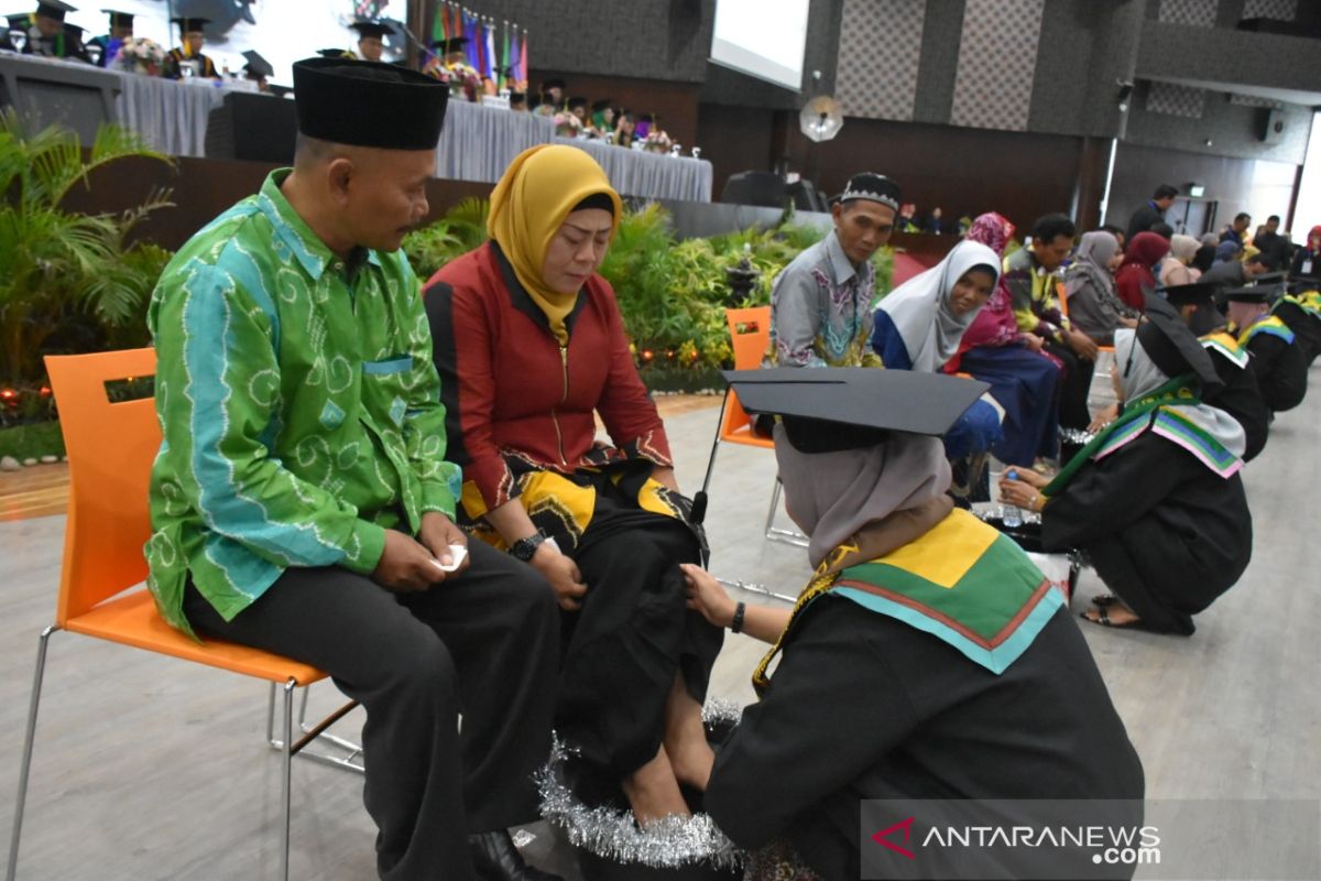 Wisudawan ULM  mencuci kaki orang tuanya