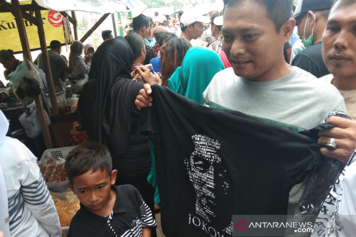 Jokowi distributes T-shirts to onlookers at Kamijoro Dam inauguration