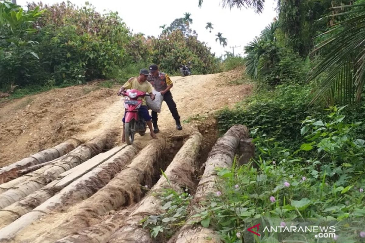 Bhabinkamtibmas di Aceh Utara bantu petani seberangi jembatan darurat