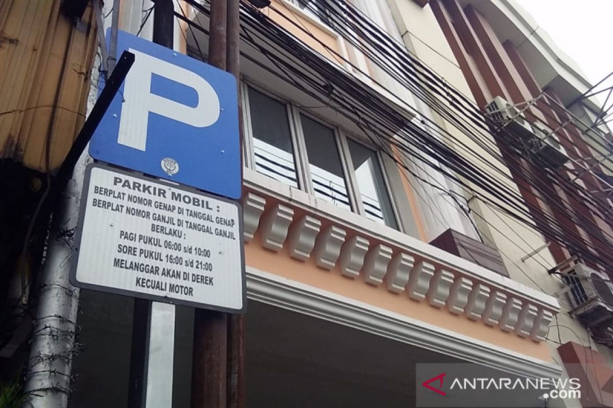 Petugas sosialisasi parkir ganjil genap ke pengemudi mobil