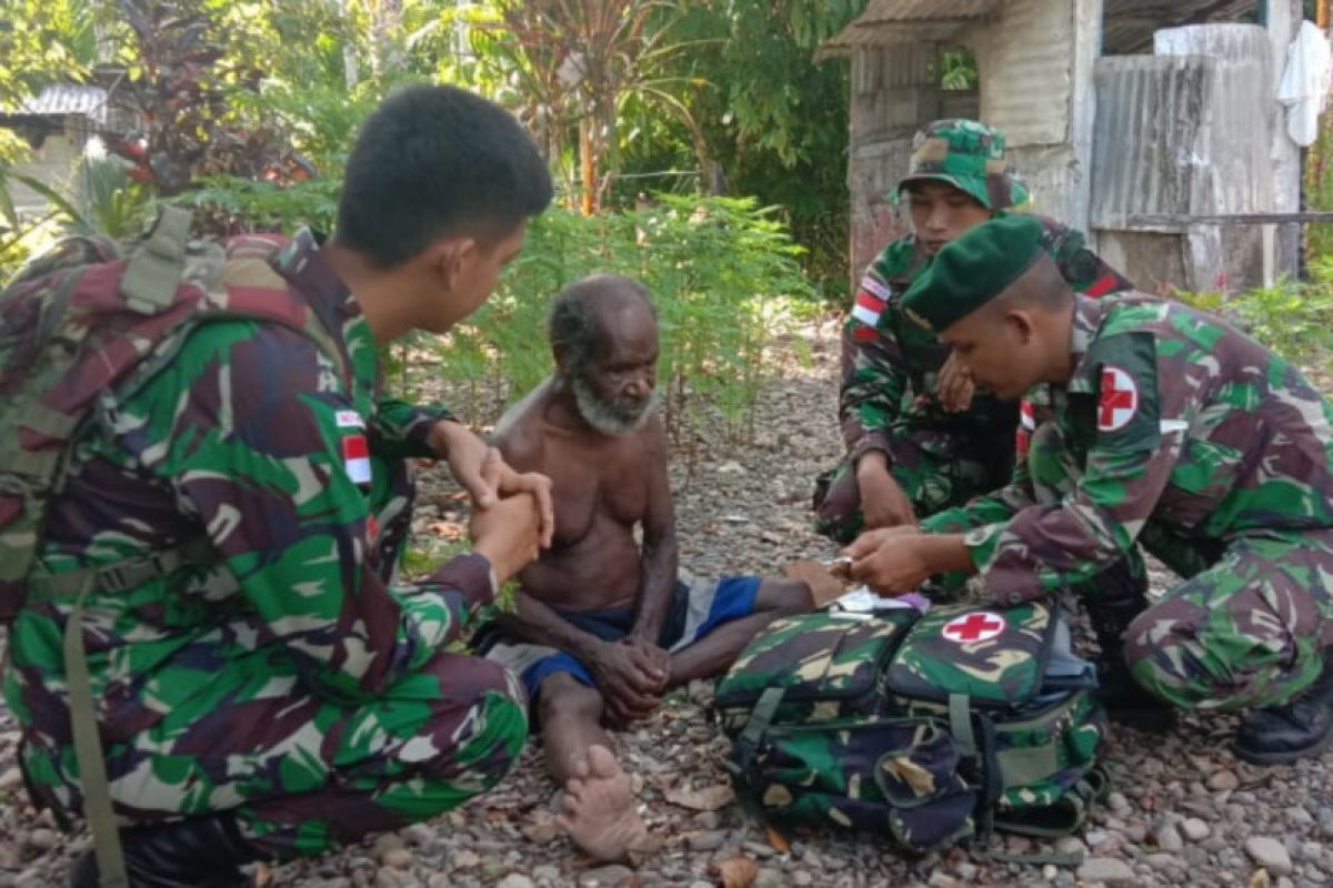 Prajurit TNI menolong warga Mimika, Papua, yang dilaporkan sakit