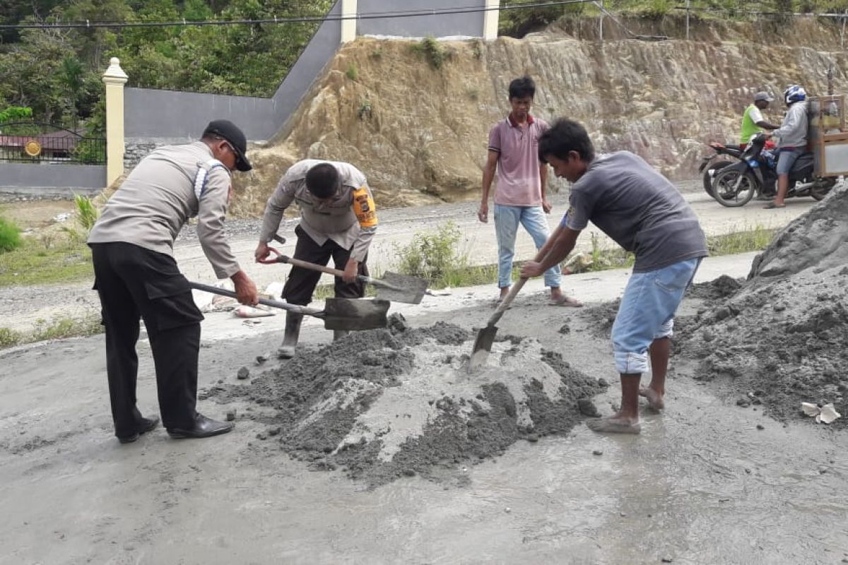 Polsek Depapre Papua dan warga kampung Waiya gotong-royong cor jalan berlubang