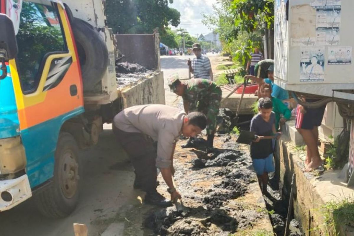 Bhabinkamtibmas Kelurahan Vim Jayapura bersama warga bersihkan selokan