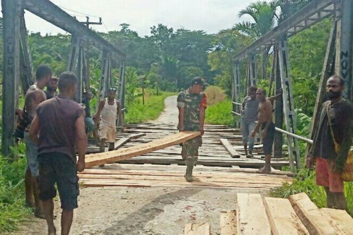 Babinsa Kemtuk Gresi bersama warga perbaiki jembatan