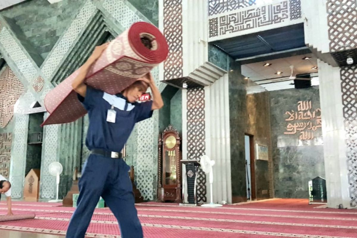 Pengurus Masjid Al Markaz Makassar bersihkan karpet antisipasi penularan Corona