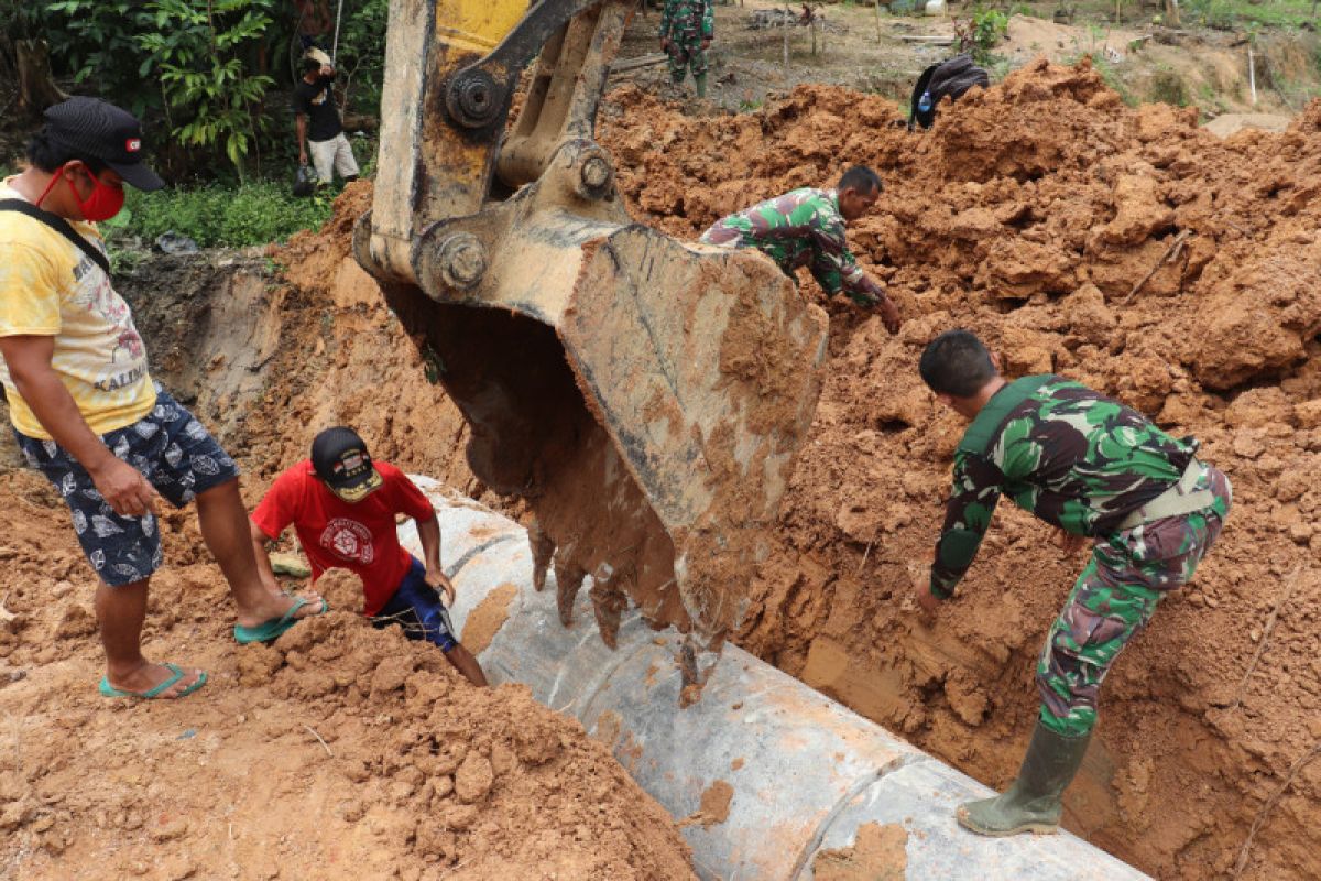 Tentara dan warga saling membantu memasang gorong-gorong