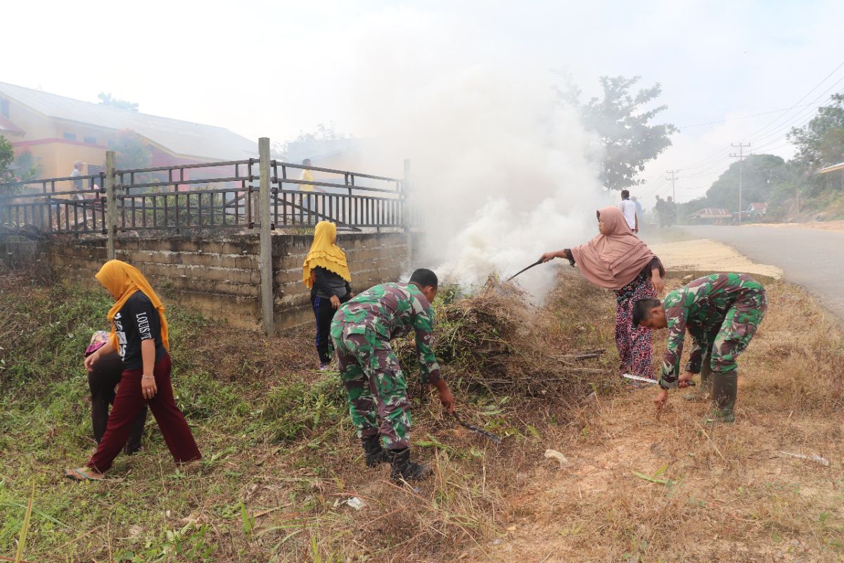 Prajurit TMMD dan ibu-ibu laksanakan kerja bakti bersihkan lingkungan