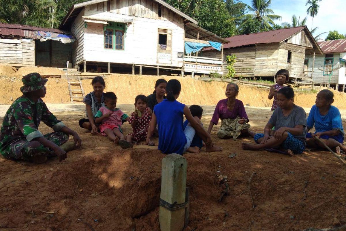 Prajurit TMMD membaur dengan ibu-ibu di Dusun Sekura
