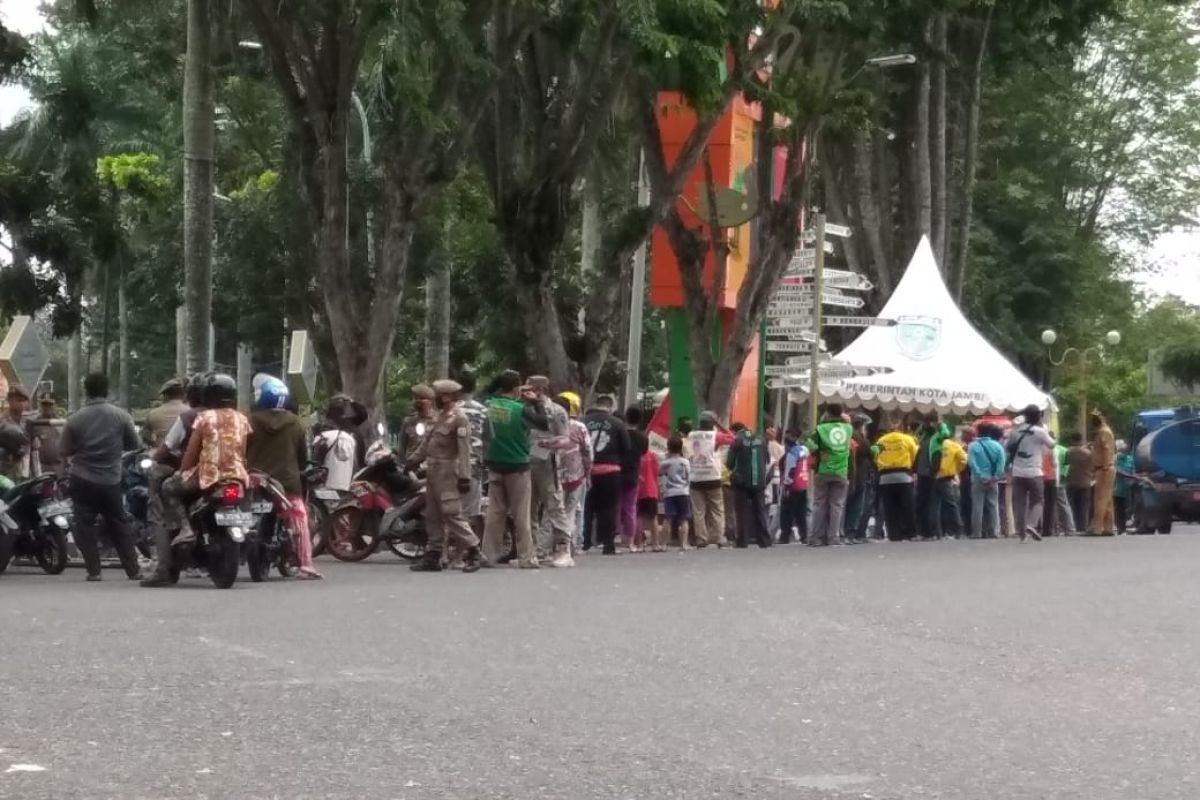 Pengemudi ojek disiplin jaga jarak saat antre makan gratis