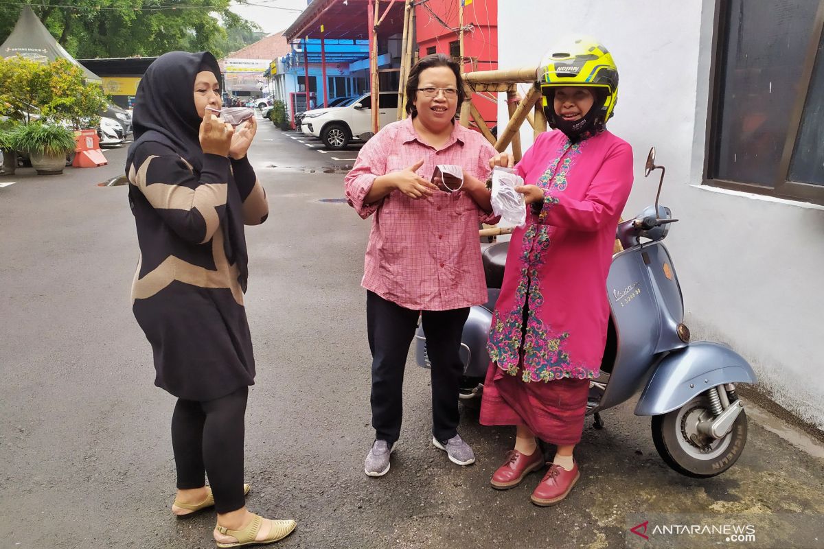 Seorang ibu berkendara Vespa berbagi masker peringati Hari Kartini