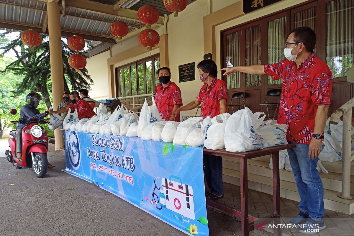 Warga Tionghoa membagikan bahan pokok kepada pemandu wisata di Mataram