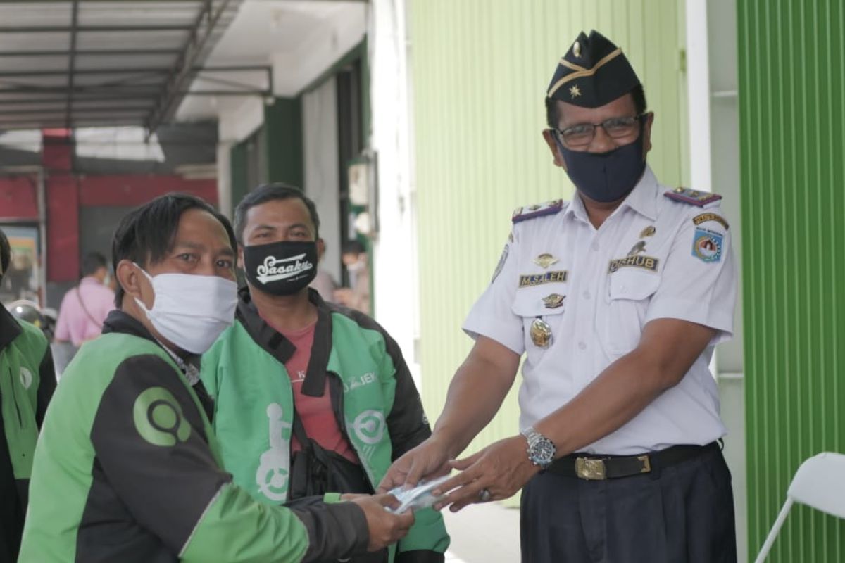 Gojek Mataram memberikan masker ke mitranya perangi COVID-19