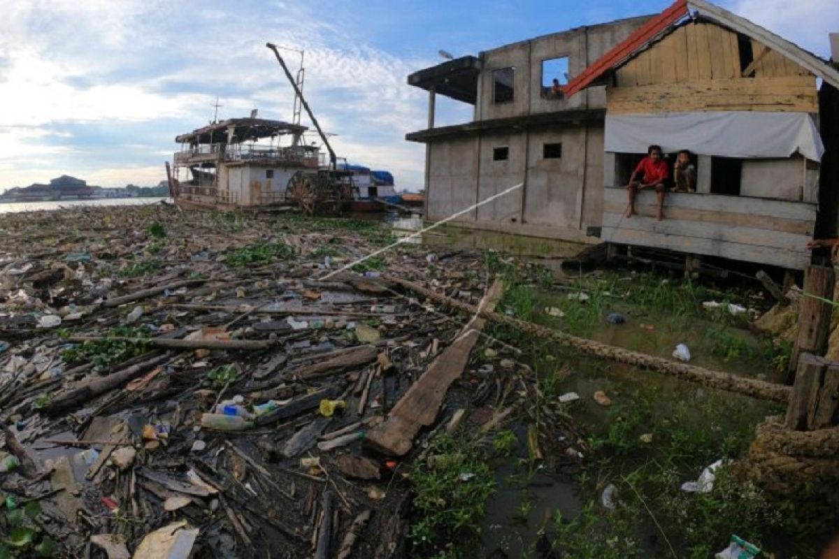 Sampah rumah tangga dan potongan kayu di Sungai Batanghari