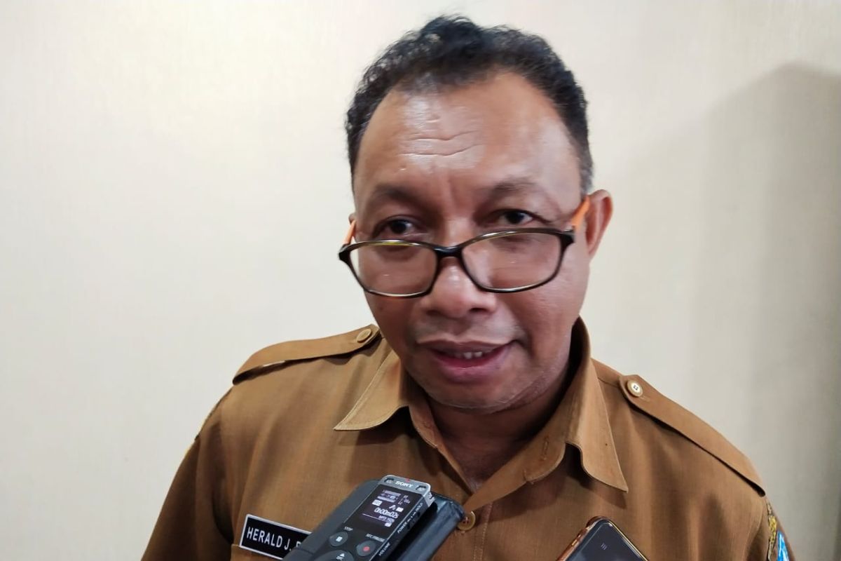 Petugas Disdukcapil Jayapura gunakan jas hujan layani masyarakat urus KTP