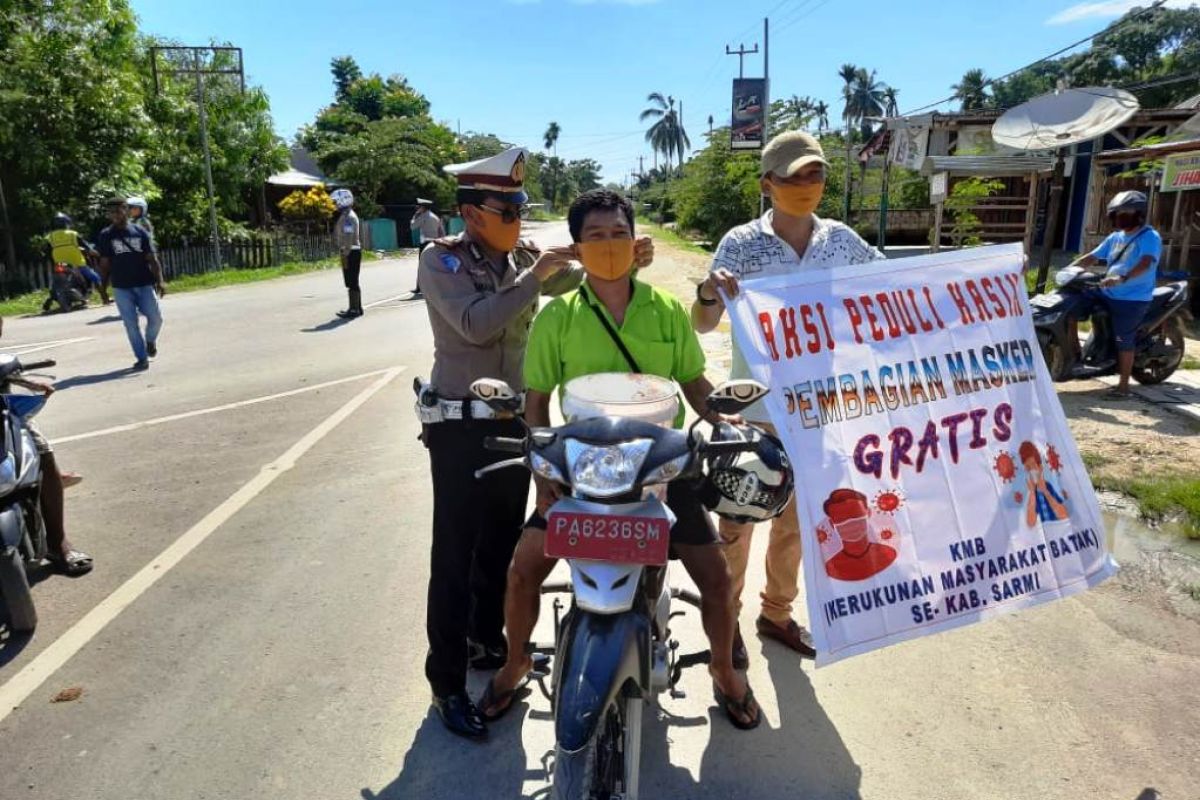 Lantas Polres Sarmi bersama Paguyuban Batak bagi masker ke warga