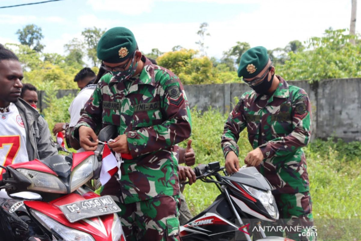 TNI pasang bendera Merah Putih di kendaraan warga yang melintasi markas