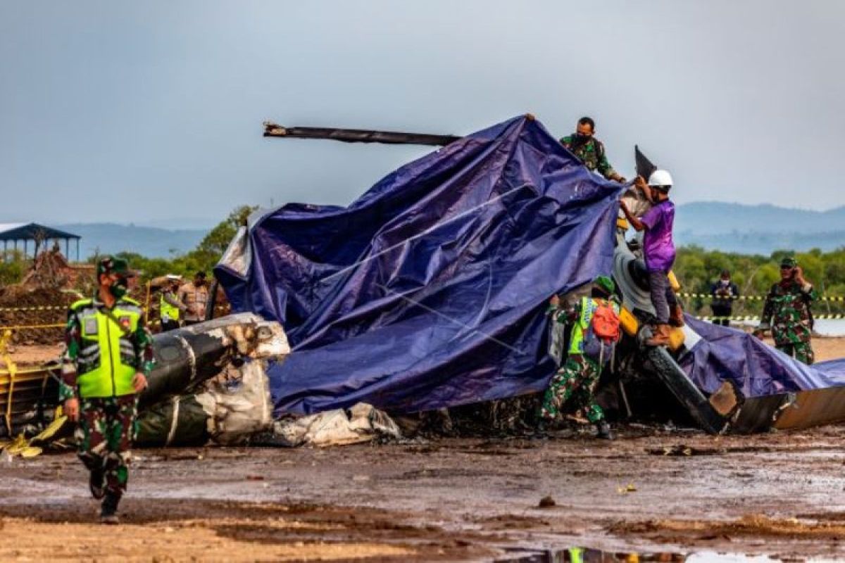 Helikopter militer jatuh ditutupi terpal, warga berkerumun menyaksikannya