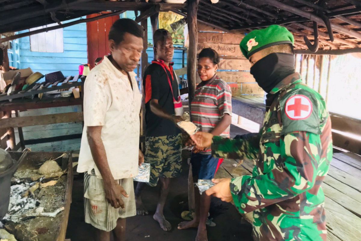 TNI lakukan penyemprotan disinfektan dan bagi masker warga kampung Rawa Biru Merauke