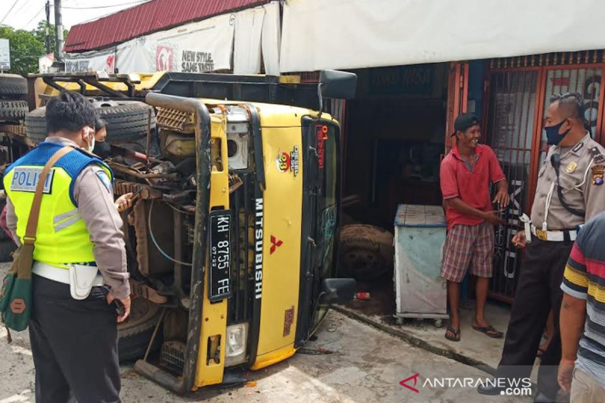 Sebuah truk terbalik usai hindari Patmor Polda Kalteng yang terjatuh