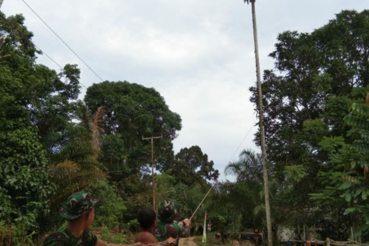 Anggota Satgas TMMD 108 bantu warga tebang pohon pinang