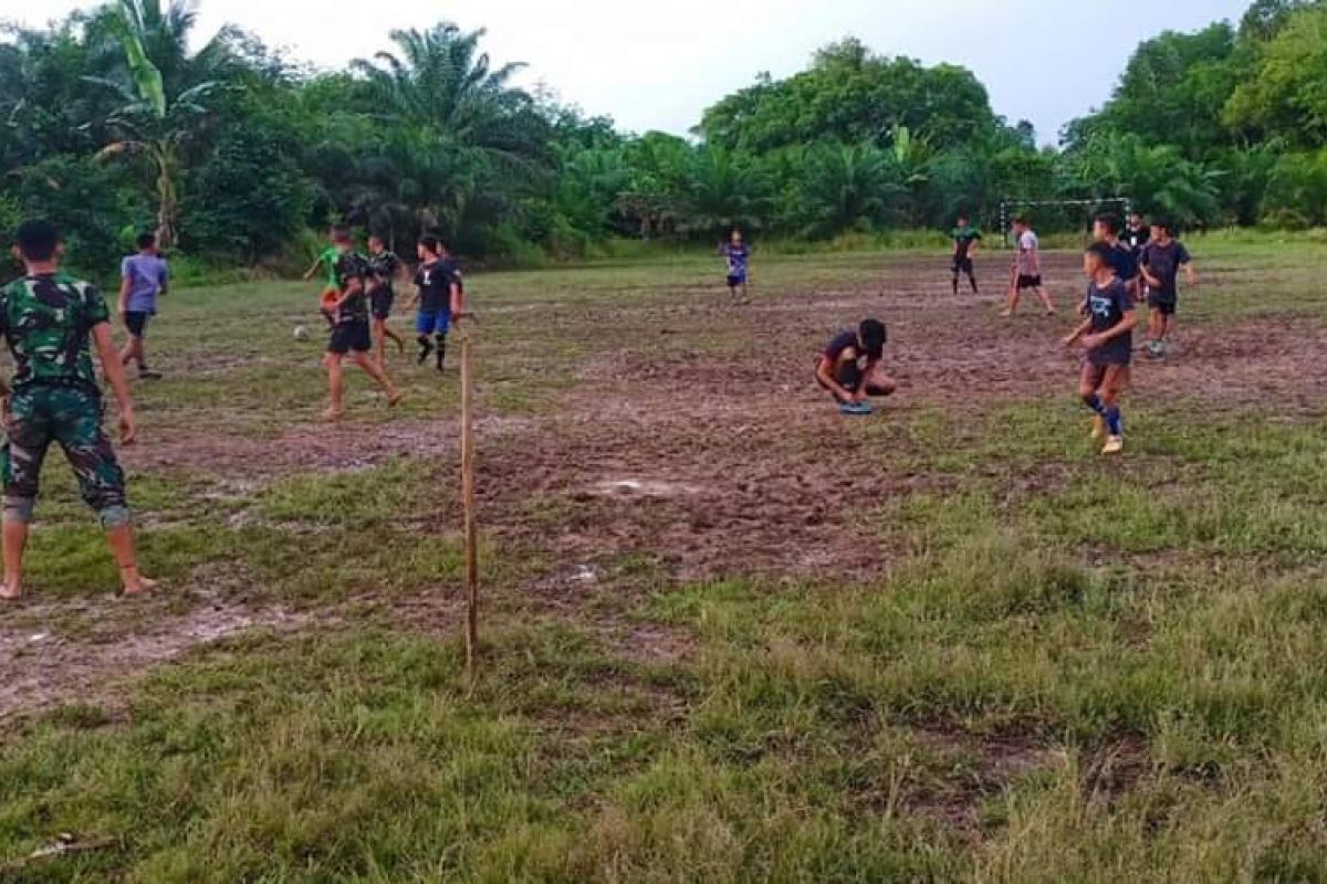 Satgas TMMD bermain sepak bolabersama pemuda