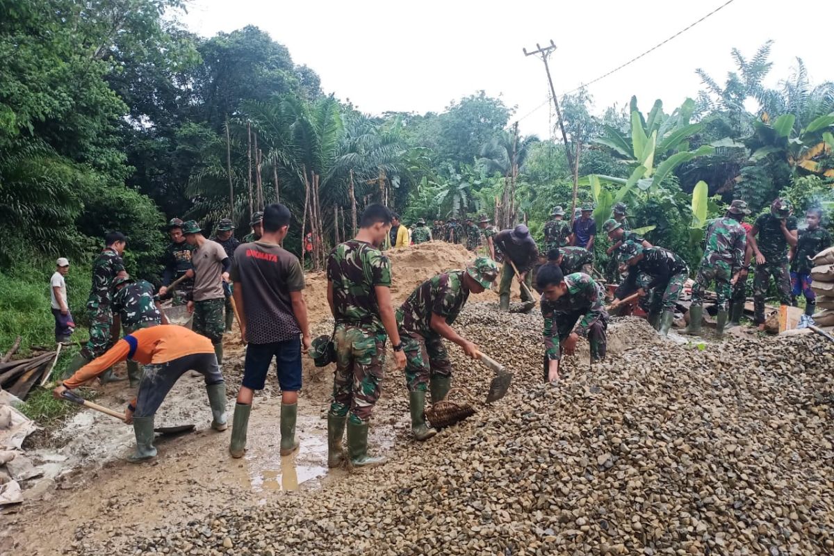 Satgas TMMD 108 Kodim 1202/ Skw bergelut dengan warga aduk semen