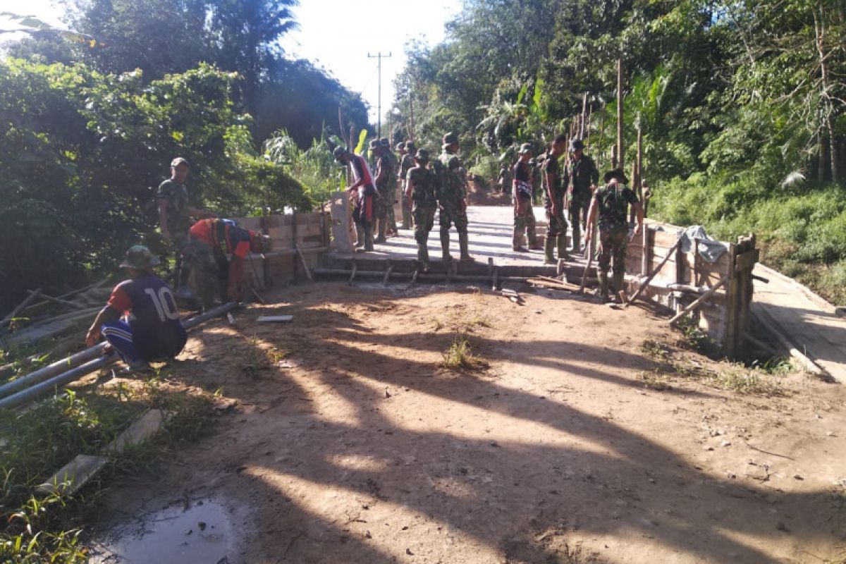 Anggota TMMD dan warga bongkar papan mal jembatan