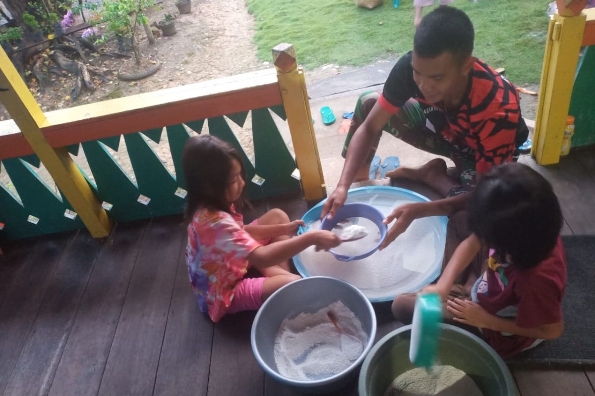 Anggota TMMD bantu warga buatkue dari tepung beras