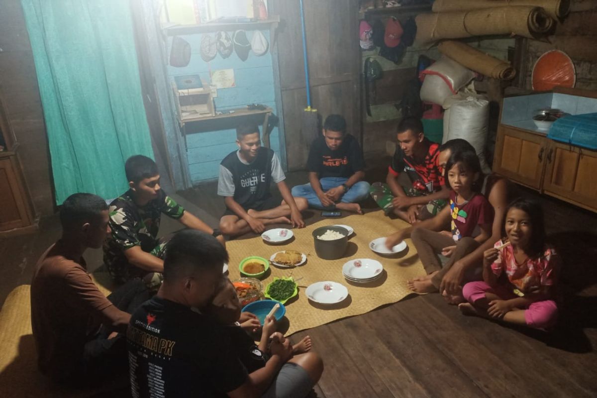 Prajurit TNI makan malam di rumah warga