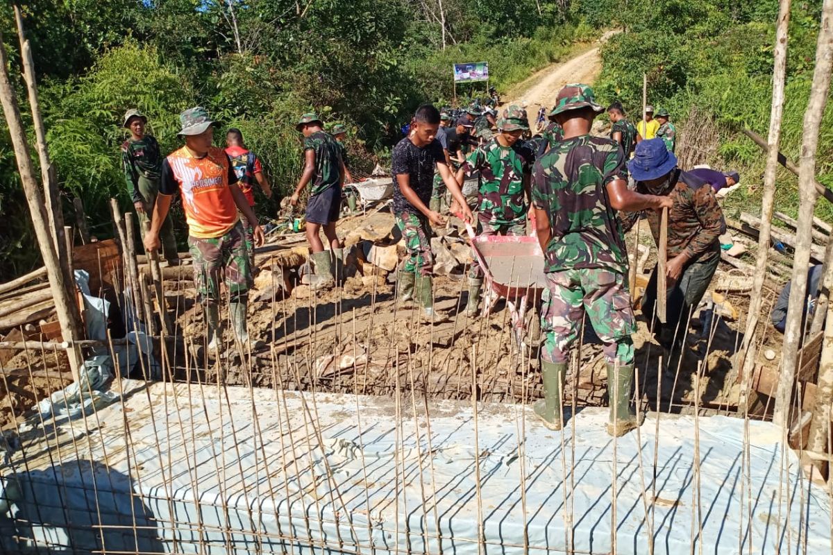 Anggota TMMD bersama warga bersemangat cor jembatan