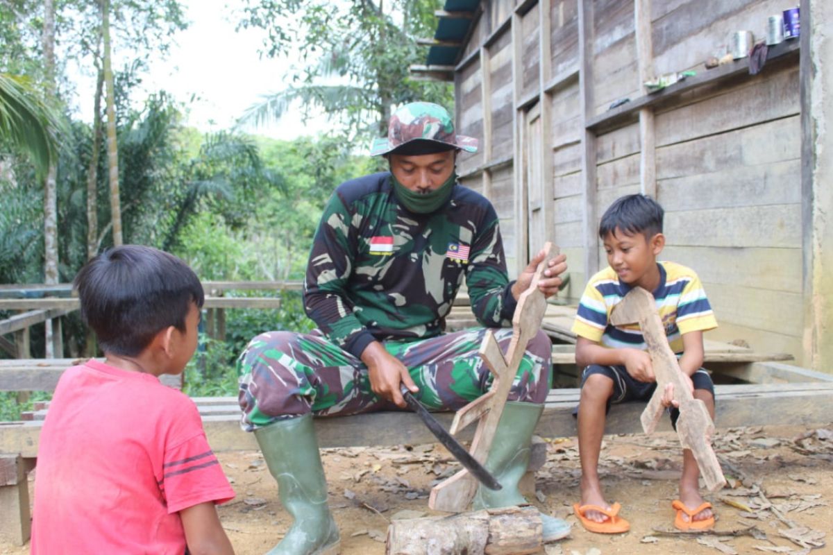 Anggota TMMD buatkan anak-anak senjata mainan