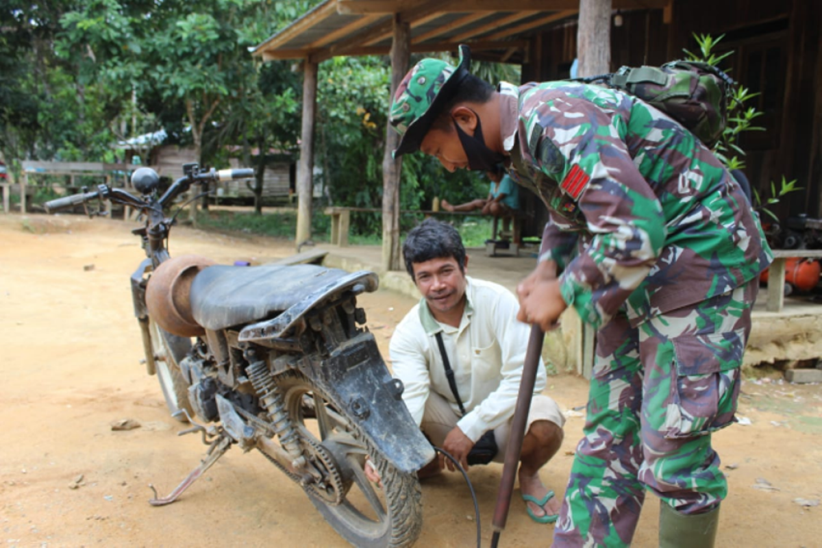 Personel TMMD bantu pompa ban sepeda motor warga