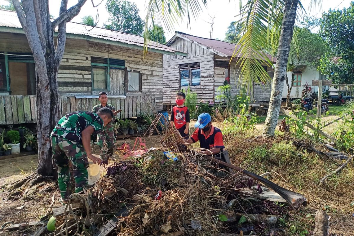 TMMD 108 bantu warga bersihkan sampah didepan rumah