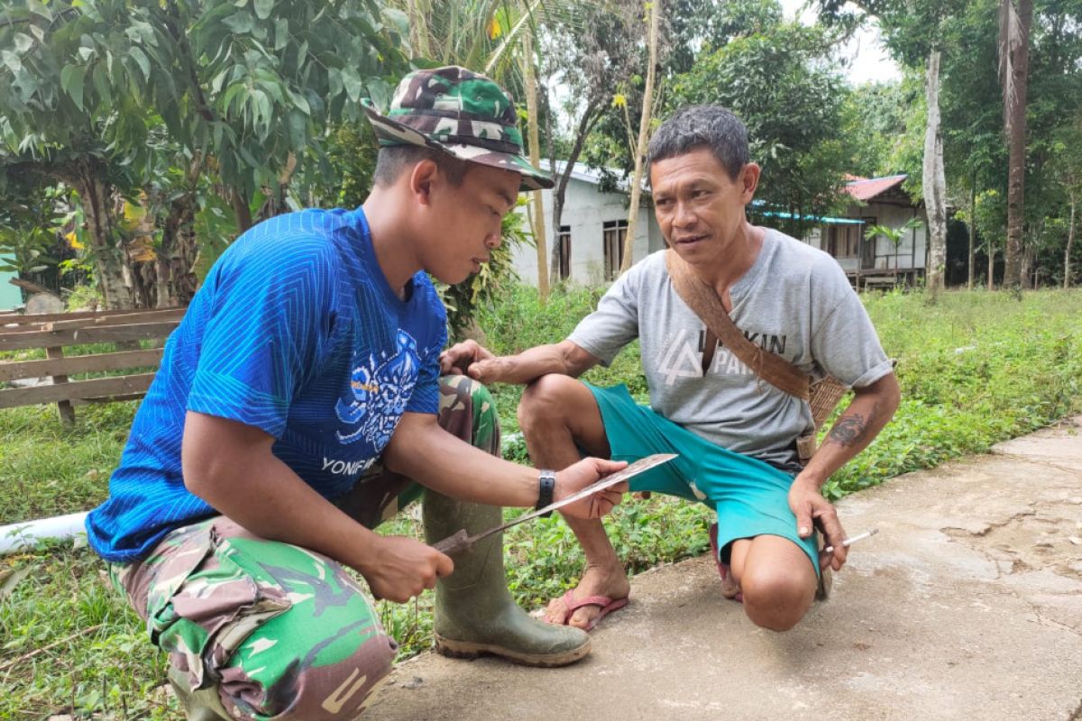 Anggota TMMD dihadiahi cendera mata sebilah parang oleh warga