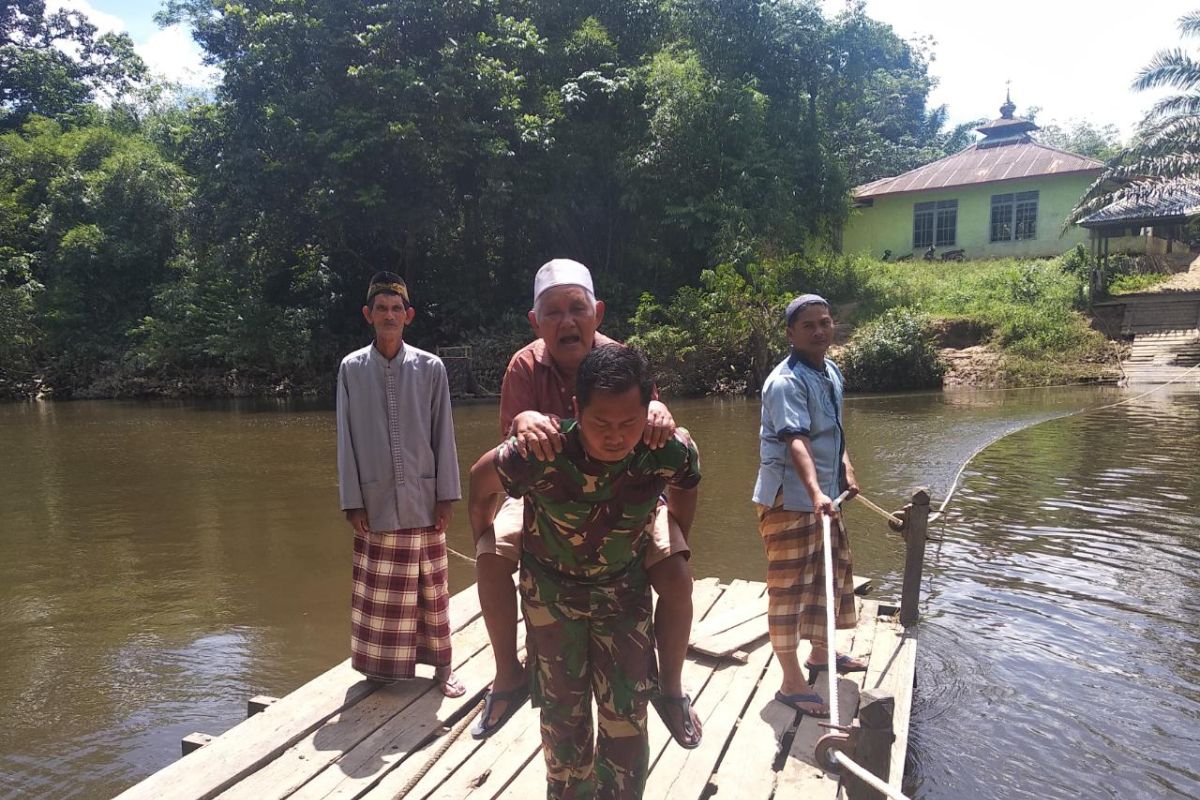 Anggota TMMD Kodim 1202/Skw bantu kakek seberangi sungai