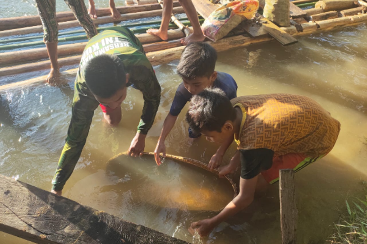 Satgas TMMD mencari ikan bersama anak-anak