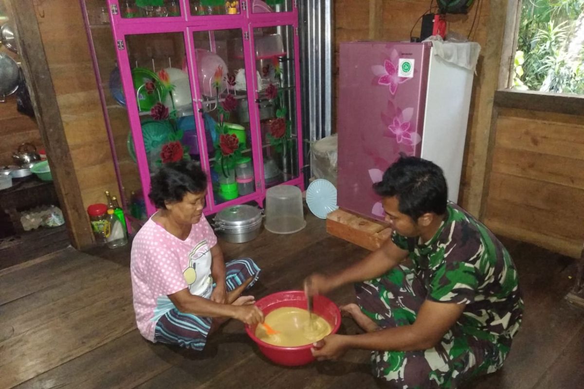 Anggota TMMD Kodim 1202/Skw bantu orang tua angkat memasak kue