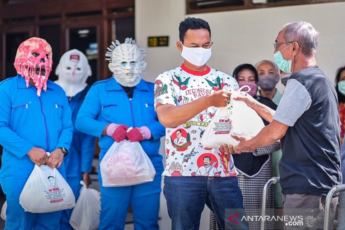 Sukarelawan Gibran bagikan sembako dengan kenakan masker corona
