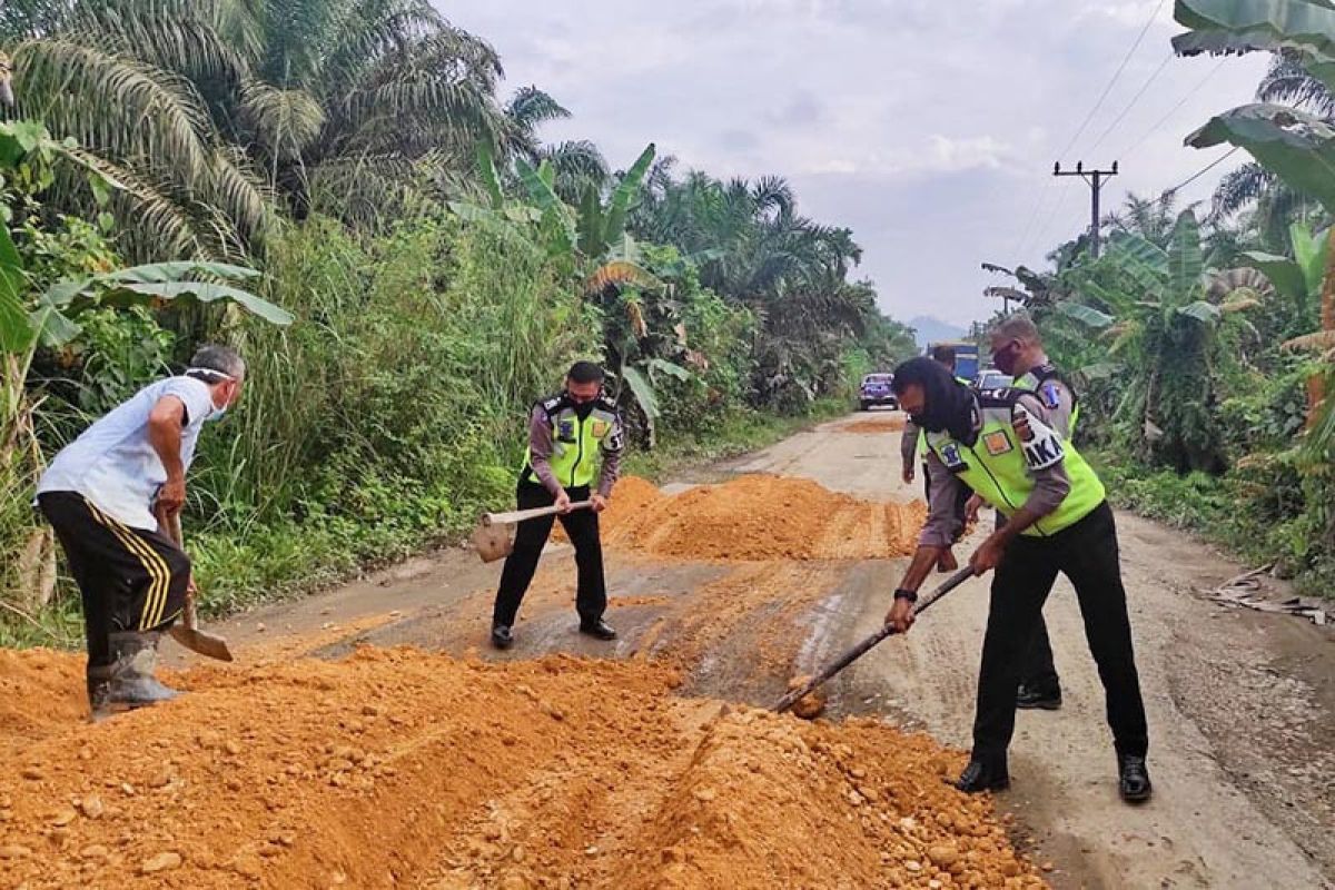 Polisi  tambal jalan berlubang saat operasi patuh di Aceh Timur