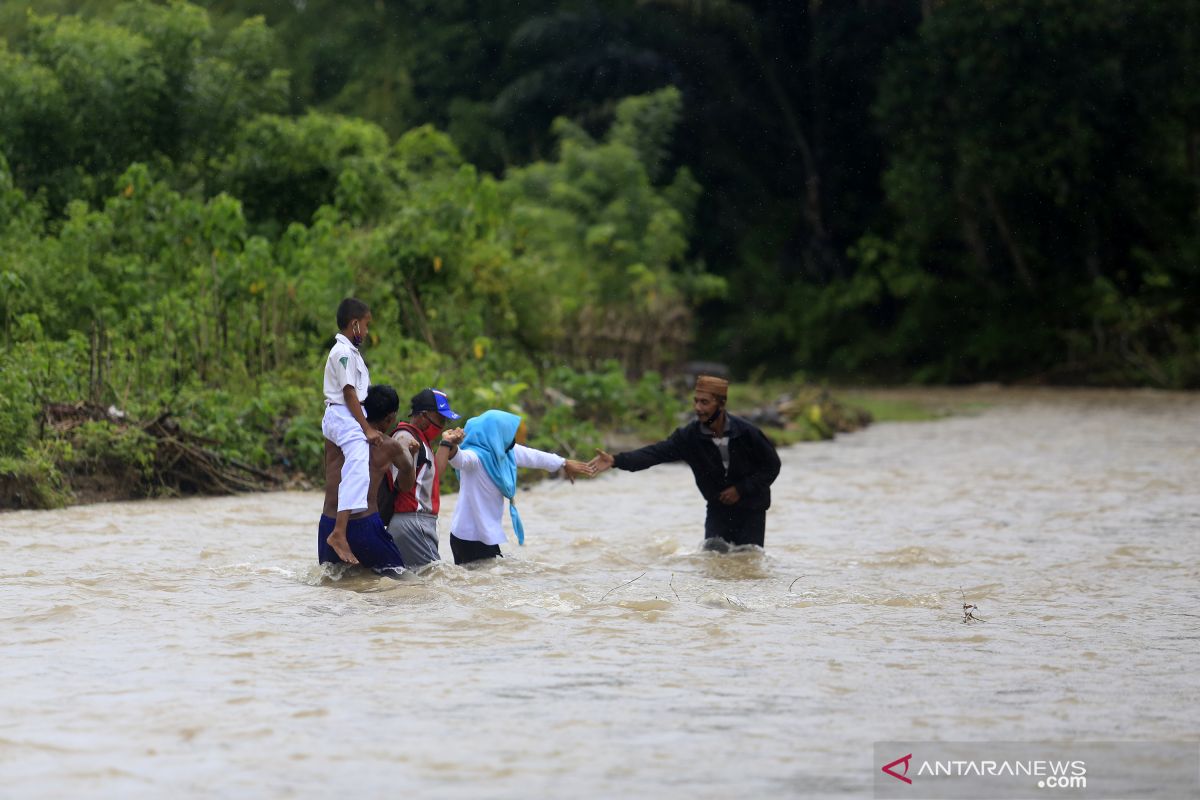 Guru SD harus menyeberangi sungai untuk mengajar