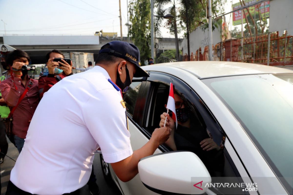 Petugas gabungan bagikan bunga saat sosialisasi ganjil-genap