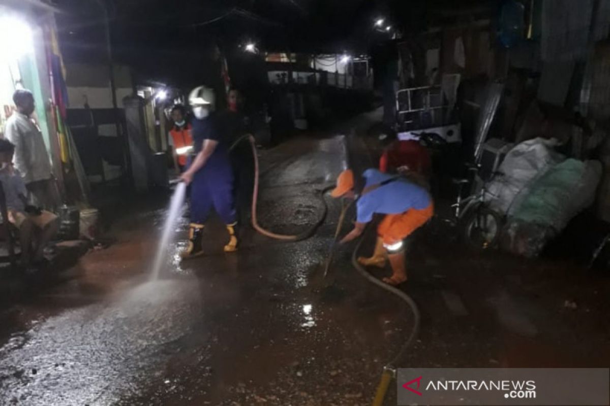 Petugas bersihkan lumpur luapan kali di Pasar Rebo