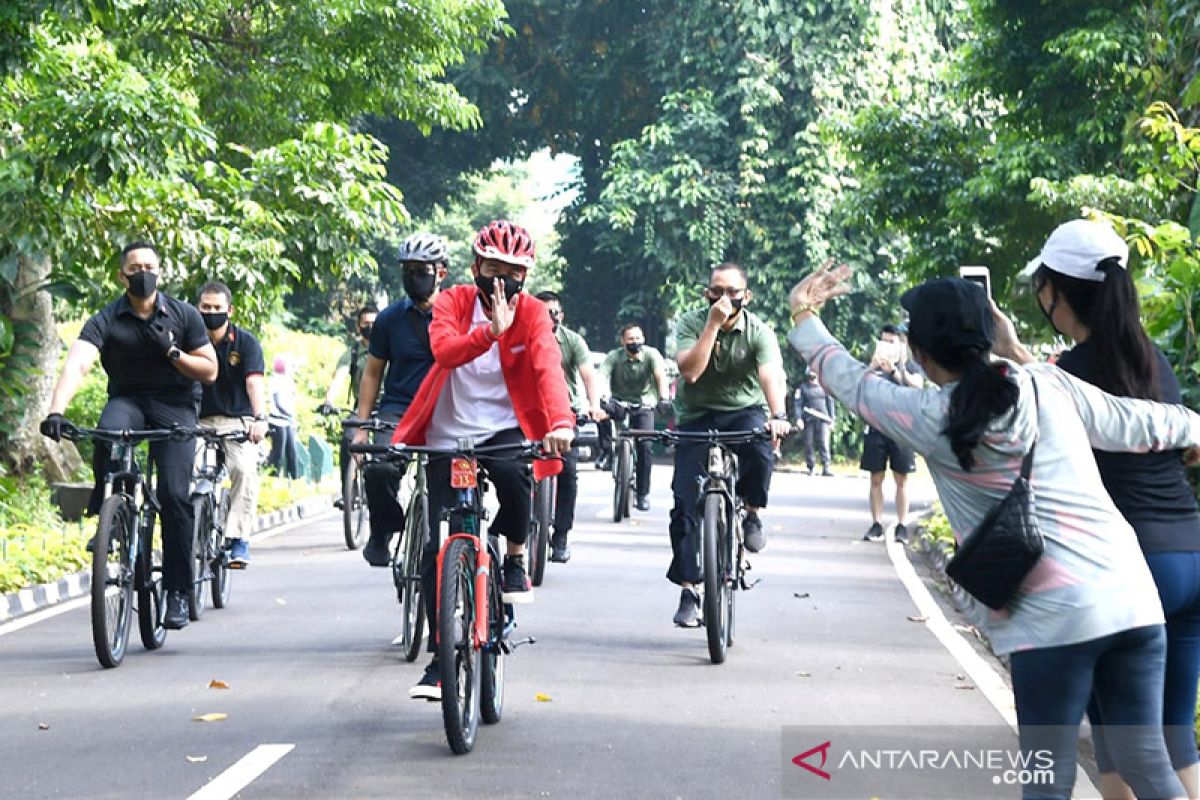 Presiden Jokowi ditemani Kaesang bersepeda dan bagikan masker di Kebun Raya Bogor