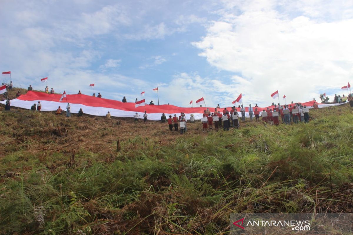 Bendera merah putih raksasa berkibar di batas Indonesia - Malaysia