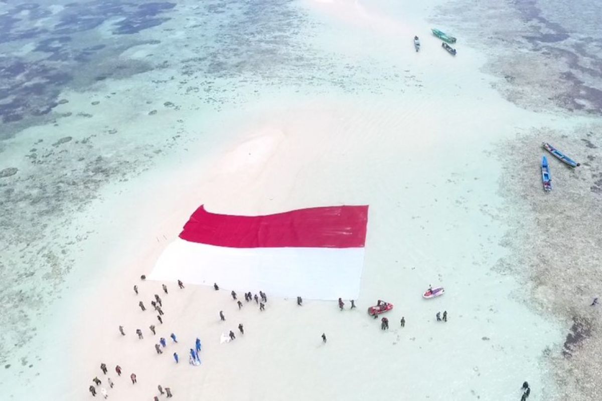 Prajurit TNI AL Lantamal VIII bentangkan Merah Putih di Pasir Timbul Nain