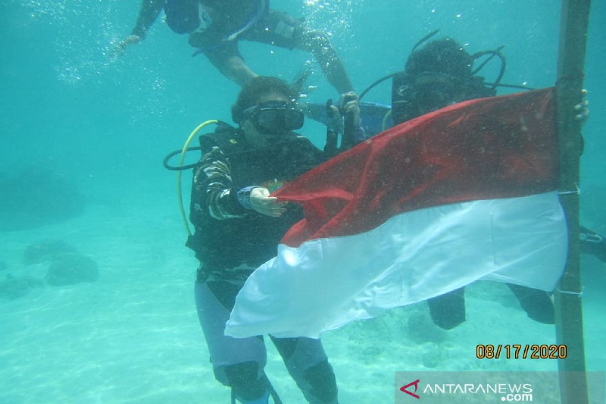 FKPPI Kendari kibarkan Merah Putih bawah laut dan tanam mangrove