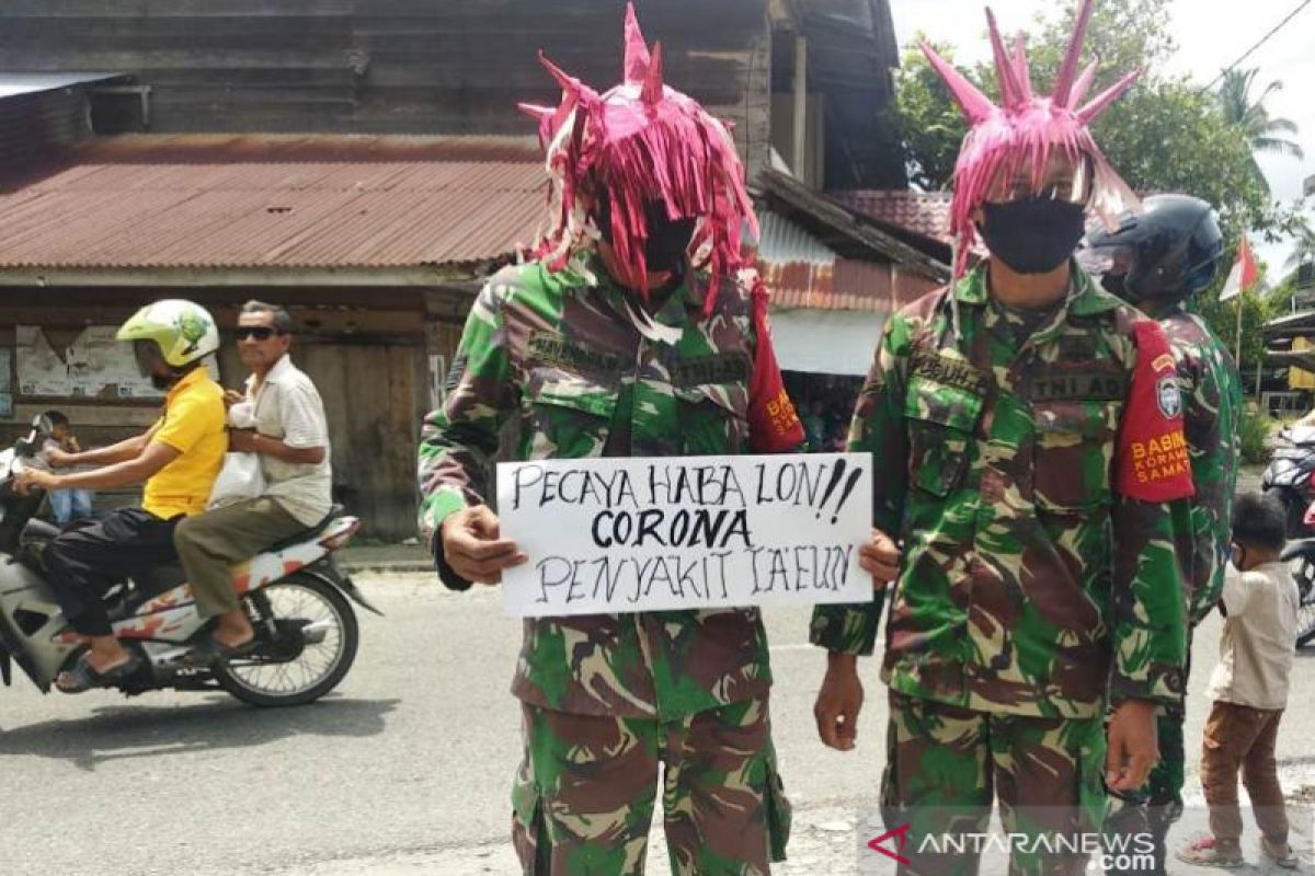 Babinsa TNI menyamar jadi 'virus corona' sadarkan warga.untuk bermasker