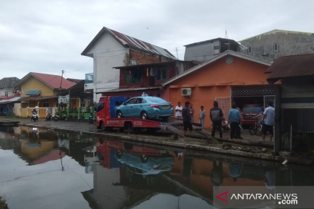 Taksi Bluebird terjun ke dalam kali saat hujan deras